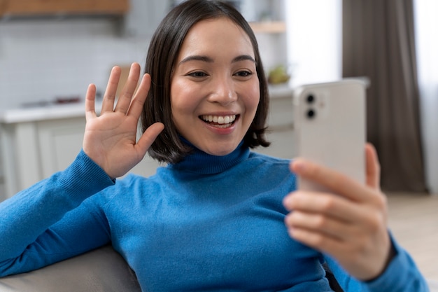 Donna sorridente del colpo medio con il telefono