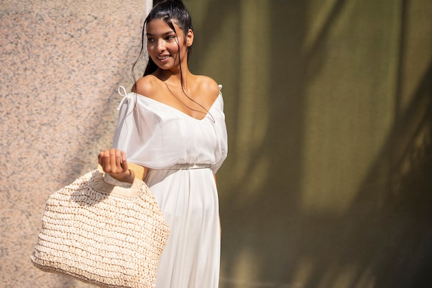 Donna sorridente del colpo medio con la borsa