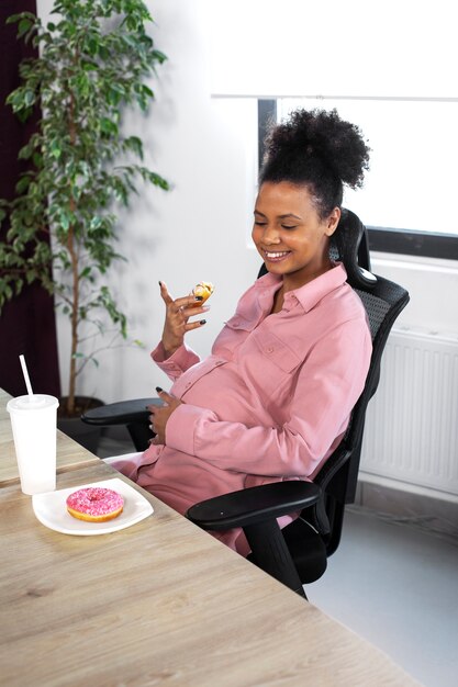 Donna sorridente del colpo medio con la ciambella