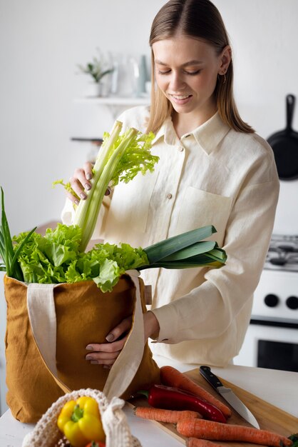 Donna sorridente del colpo medio con le verdure