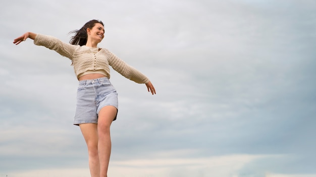 Donna sorridente del colpo pieno che posa fuori