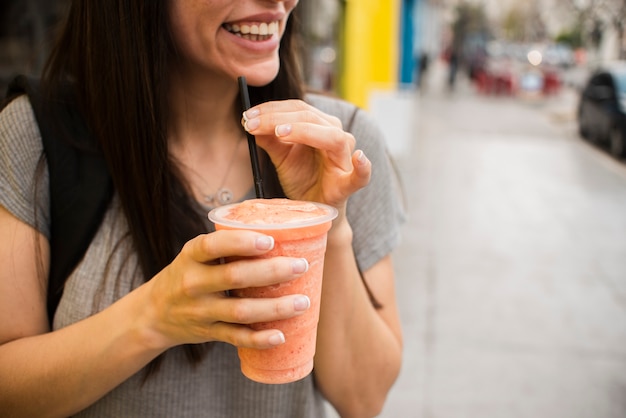 Donna sorridente del primo piano con succo