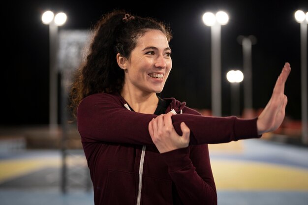 Donna sorridente del tiro medio che allunga il braccio