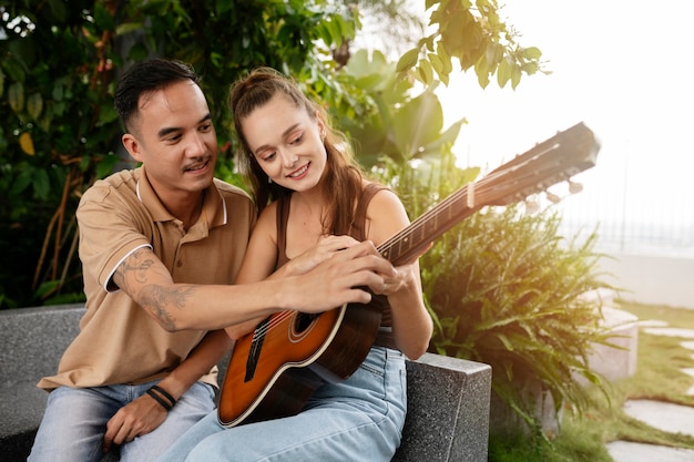 Donna sorridente di colpo medio che suona la chitarra