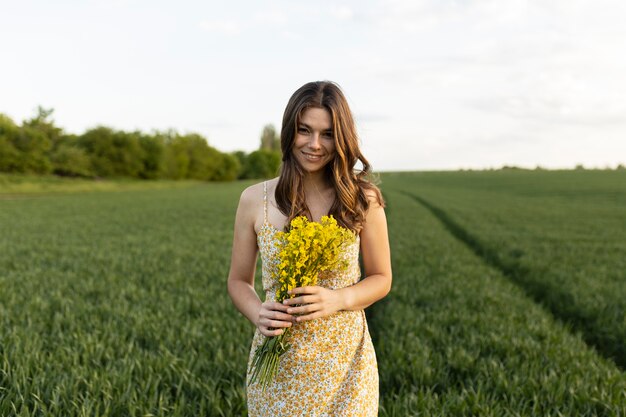 Donna sorridente di colpo medio che tiene i fiori