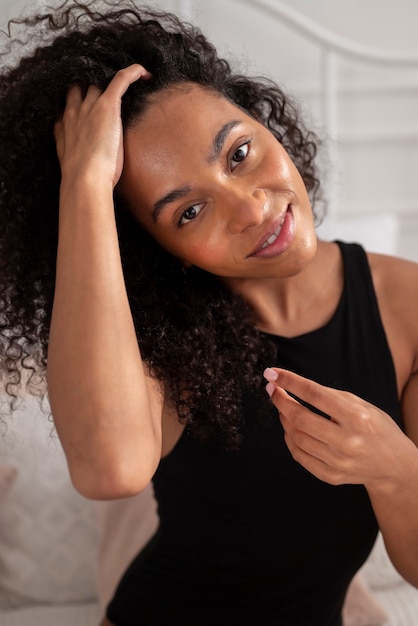 Donna sorridente di colpo medio con capelli afro