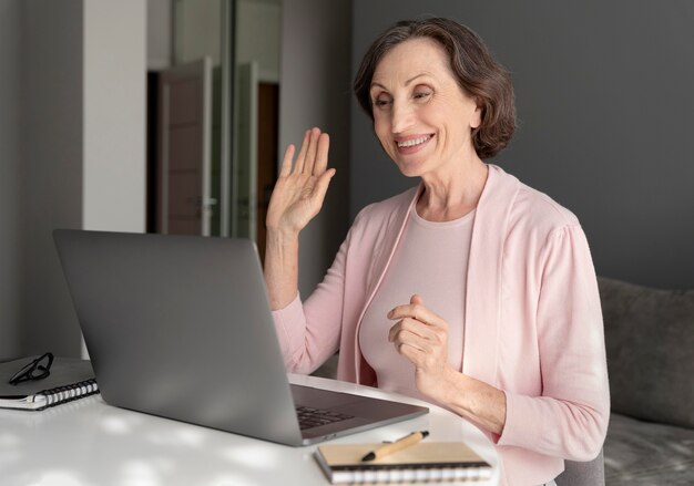 Donna sorridente di colpo medio con il computer portatile