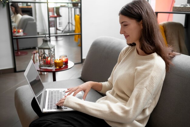 Donna sorridente di colpo medio con il computer portatile