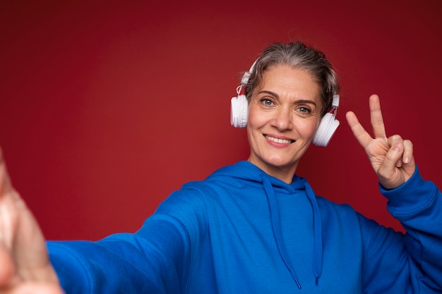 Donna sorridente di colpo medio con le cuffie