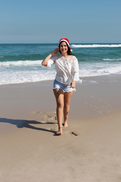 Donna sorridente di vista frontale che cammina sulla spiaggia
