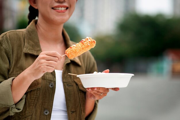 Donna sorridente di vista frontale che mangia cane del cereale