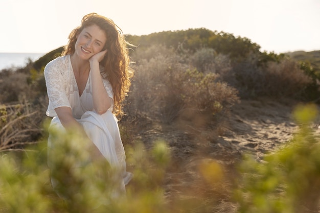 Donna sorridente di vista frontale che posa al mare