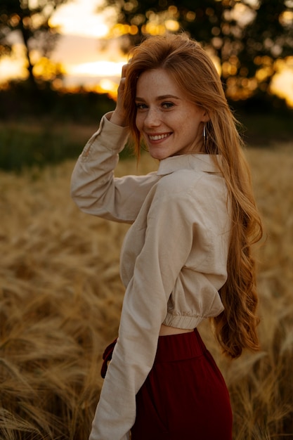 Donna sorridente di vista laterale che posa all'aperto