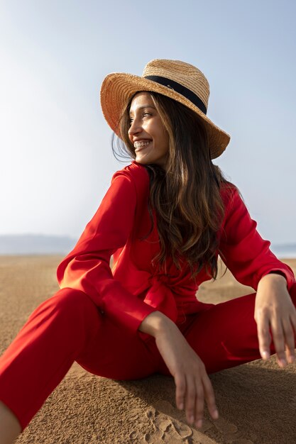 Donna sorridente di vista laterale che posa nel deserto