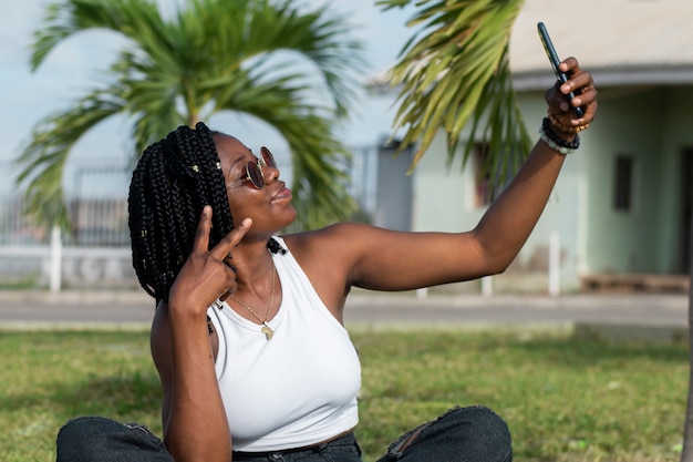 Donna sorridente di vista laterale che prende selfie