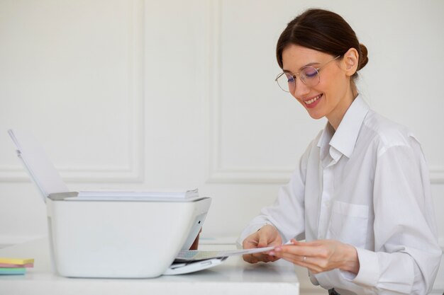 Donna sorridente di vista laterale che utilizza la stampante