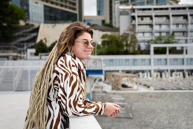 Donna sorridente di vista laterale con i dreadlocks afro