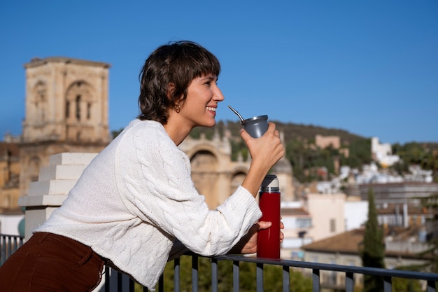 Donna sorridente di vista laterale con la bevanda