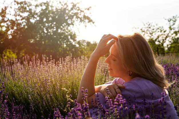 Donna sorridente di vista laterale nel campo di lavanda