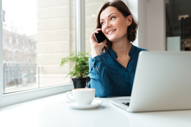 Donna sorridente felice che parla sul telefono cellulare