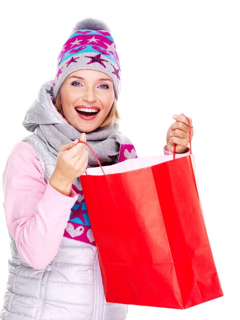 Donna sorridente felice con doni dopo lo shopping isolato su bianco