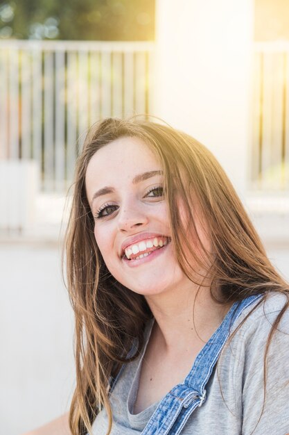 Donna sorridente graziosa che esamina macchina fotografica