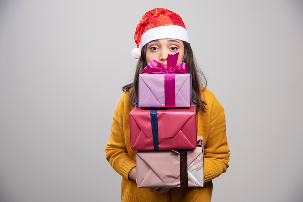 Donna sorridente in contenitori di regalo della holding del cappello della Santa.