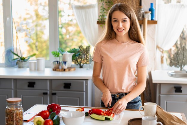 Donna sorridente in cucina che cucina con lo spazio della copia