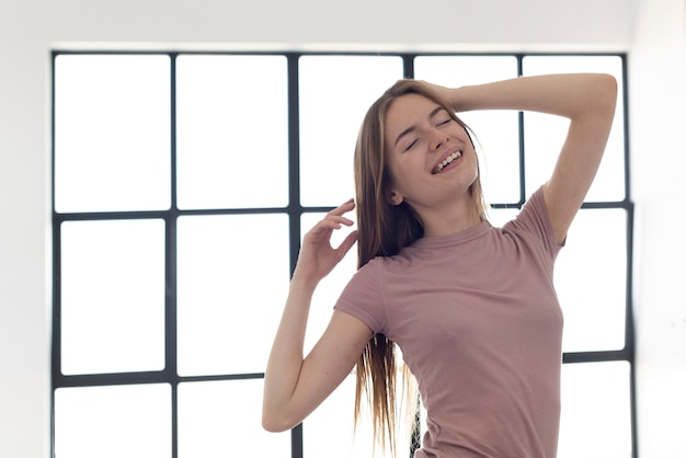 Donna sorridente in piedi accanto a una finestra