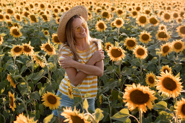 Donna sorridente in posa nel campo di girasoli