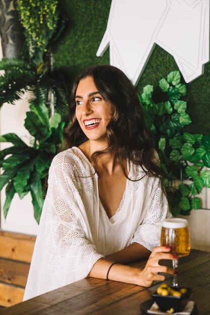 Donna sorridente in possesso di una birra