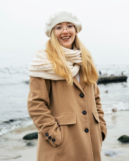 Donna sorridente in spiaggia in inverno