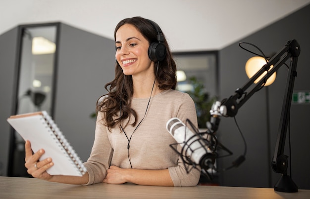 Donna sorridente in studio durante un programma radiofonico