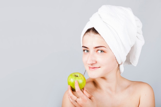 Donna sorridente nella mela della holding di asciugamano