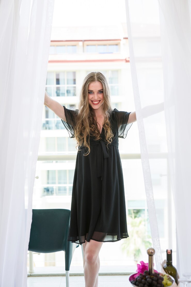 Foto gratuito donna sorridente tra due tende bianche