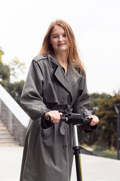 Donna sorridente utilizzando scooter elettrico all'aperto