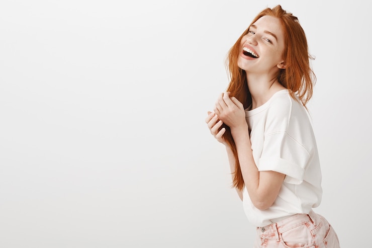 Foto gratuito donna spensierata rossa felice ridendo e sorridendo, godendo l'estate