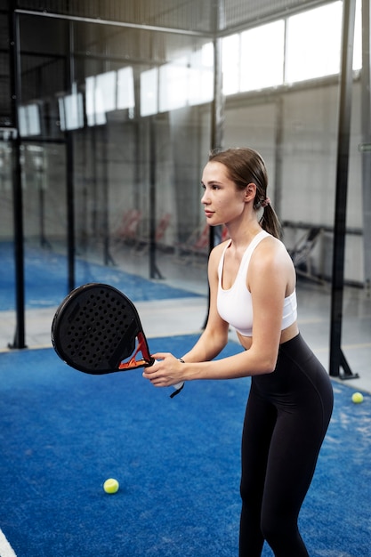 Donna sportiva che gioca colpo medio di paddle tennis