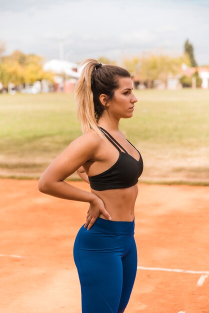 Donna sportiva che sta sulla pista dello stadio