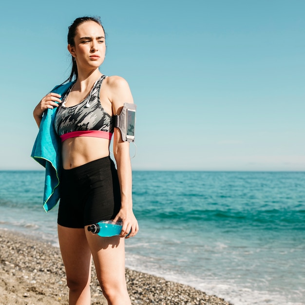 Donna sportiva in piedi sulla spiaggia