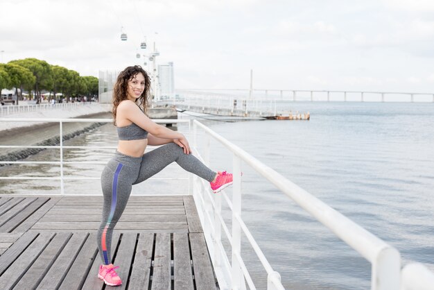 Donna sportiva positiva che esercita sulla città di Quay