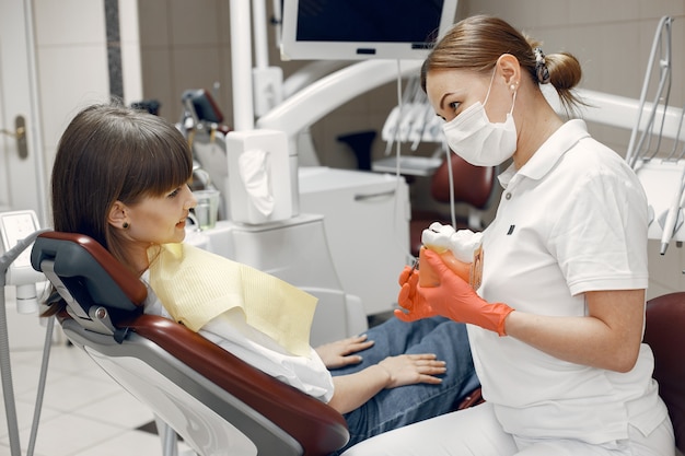 Donna su una poltrona odontoiatrica. Il dentista insegna la cura adeguata La bellezza tratta i suoi denti