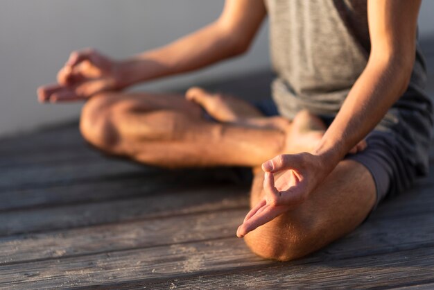 Donna sul molo facendo sukhasana