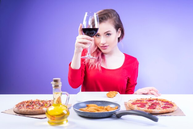 Donna sveglia che alza un bicchiere di vino rosso