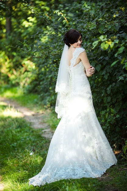 Donna sveglia con il suo abito da sposa all&#39;aperto