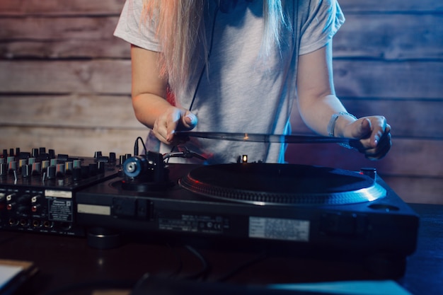 Donna sveglia del DJ divertendosi giocando la musica alla festa del club