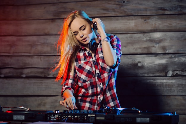 Donna sveglia del DJ divertendosi giocando la musica alla festa del club