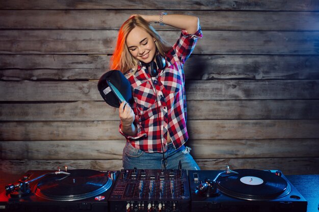 Donna sveglia del DJ divertendosi giocando la musica alla festa del club