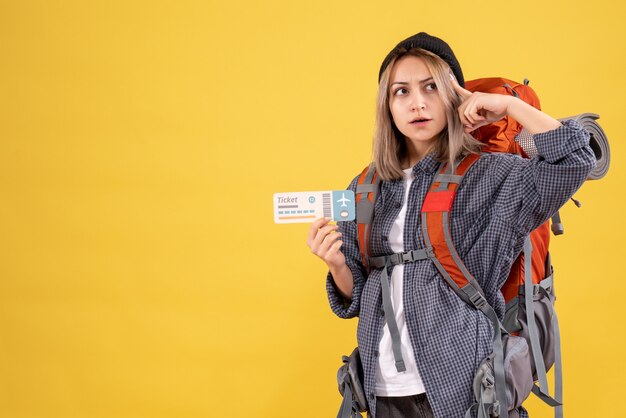 donna viaggiatrice con zaino in possesso di biglietto pensando a qualcosa