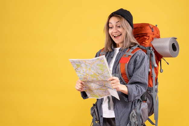 donna viaggiatrice felicissima con lo zaino che guarda la mappa